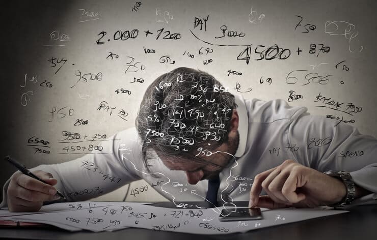 Businessman trying to figure some numbers out leaning on the table