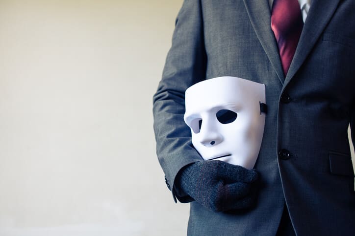 Businessman carrying white mask - business fraud and faking concept